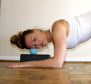 Relieve jaw and head tension with a Yoga Tune Up® Therapy ball on your temple.
